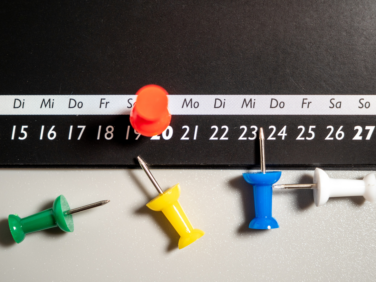 Close-up of a black calendar page with push pins. / Jakob Berg Close-up of a black calendar page with push pins. Time concept.