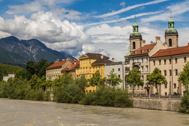 The outside of Innsbruck Cathedral during the day from across the River Inn.