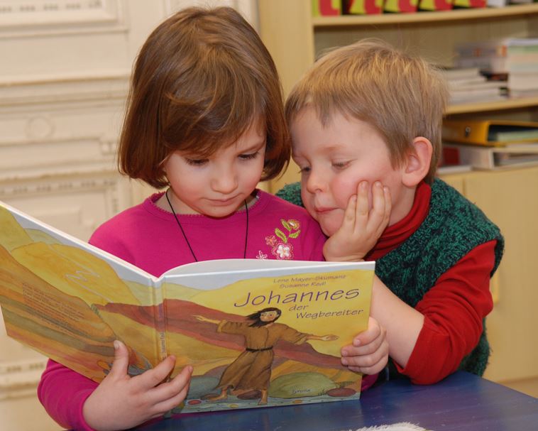 Kinder lesen ein Buch.