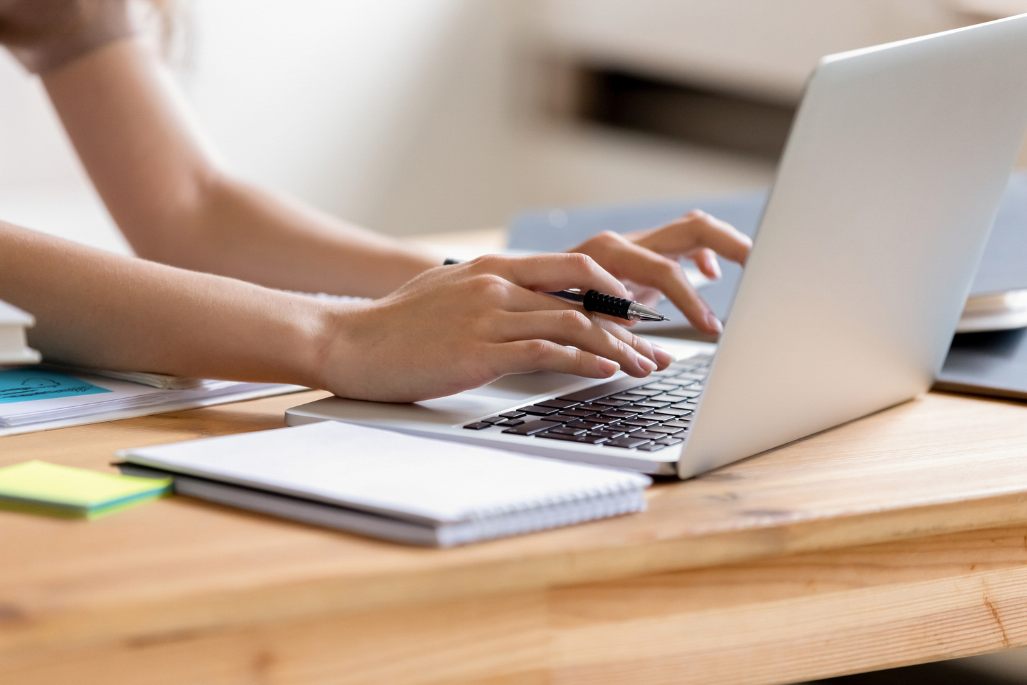 Closeup cropped image student girl hands typing using laptop / fizkes Cropped close up image woman hands holding pen typing on laptop student do homework prepare essay make research, businesswoman communicate online with client solve business questions distantly concept