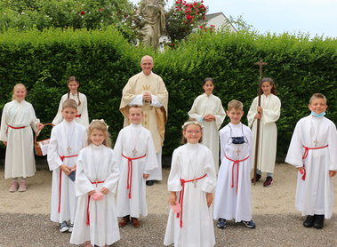 Die Erstkommunionkinder mit Pfarrer P. Michael und den Ministrantinnen.
