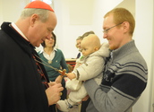 Kardinal Schönborn mit einem Vater mit Baby / kathbild.at/Rupprecht, Franz Josef Rupprecht