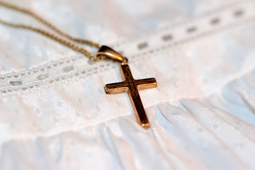 Kreuz und Taufkleid - zwei Symbole der Taufe
