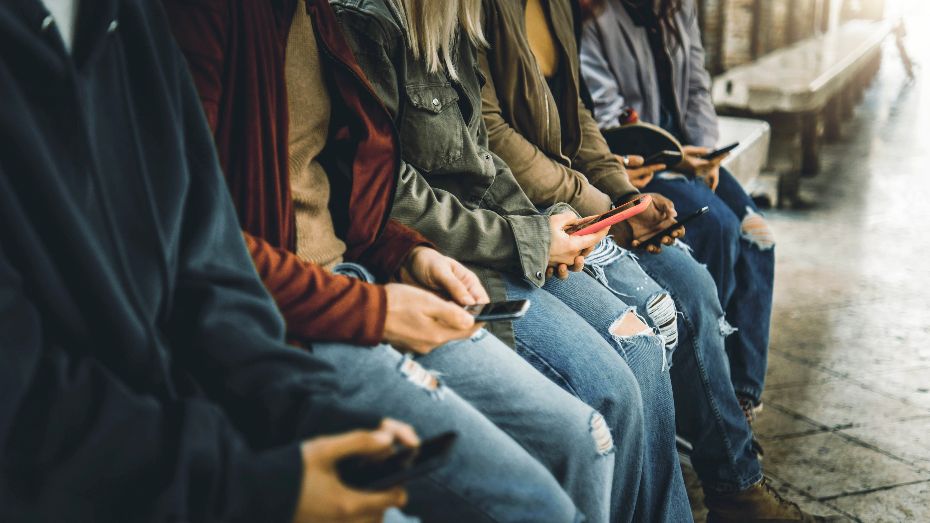 Millenial people watching smart mobile phones outside - Teens using modern technology - Young people addicted to cellphones 