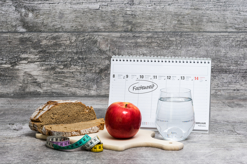 Diet meal on a grey background with calendar and the german word for Lent 'Fastenzeit'.