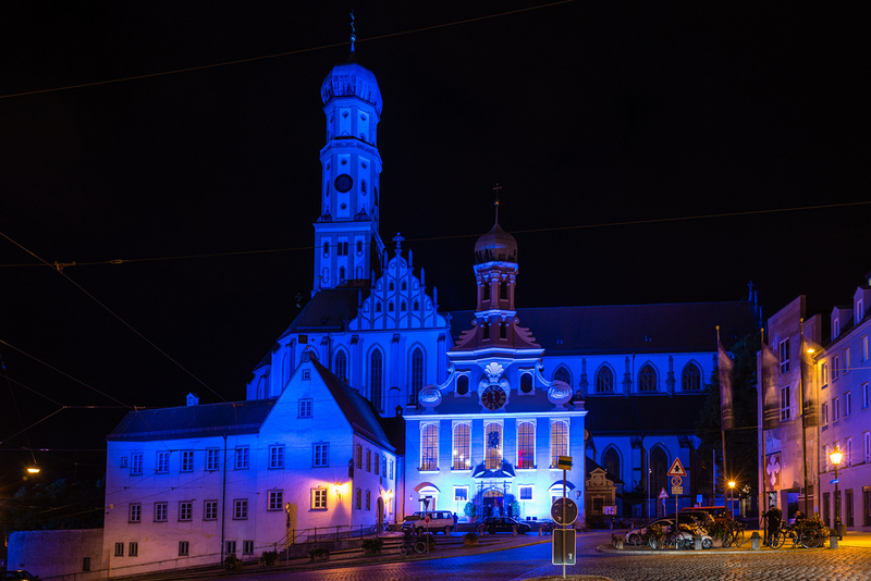 Augsburg, Germany - June 20, 2015: The St. Ulrich Basilica is illuminated in blue at night during the festival “the long night of lights” in Augsburg, Germany. Augsburg is an ancient roman city that dates back to 15 before Christ.  