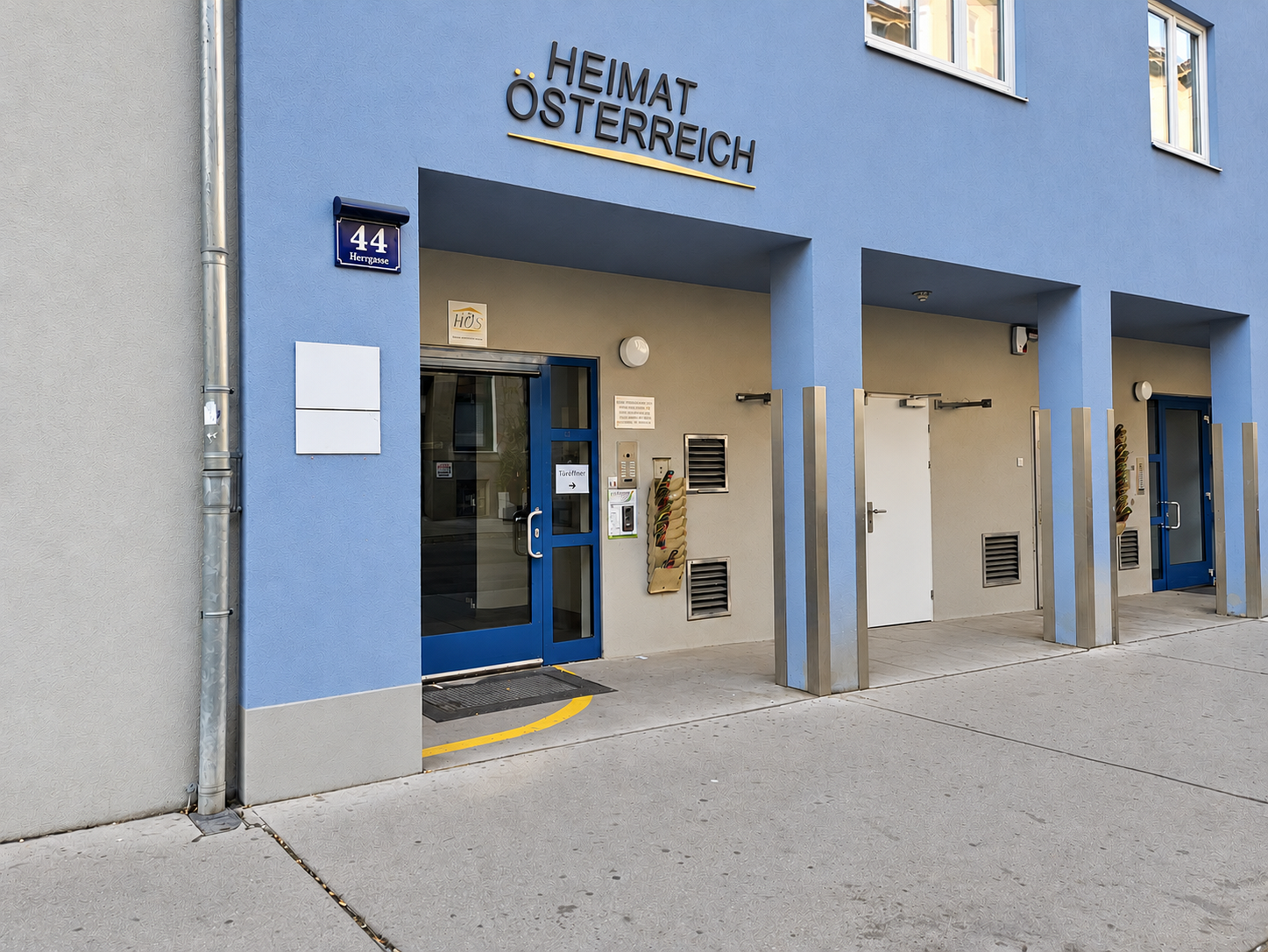 Straßenseitiger Blick auf blaues Haus der Beratungsstelle mit zwei eckigen Säulen über den Eingangsbereich.
