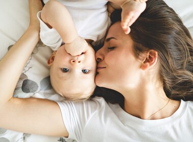 A happy mother with baby on bed