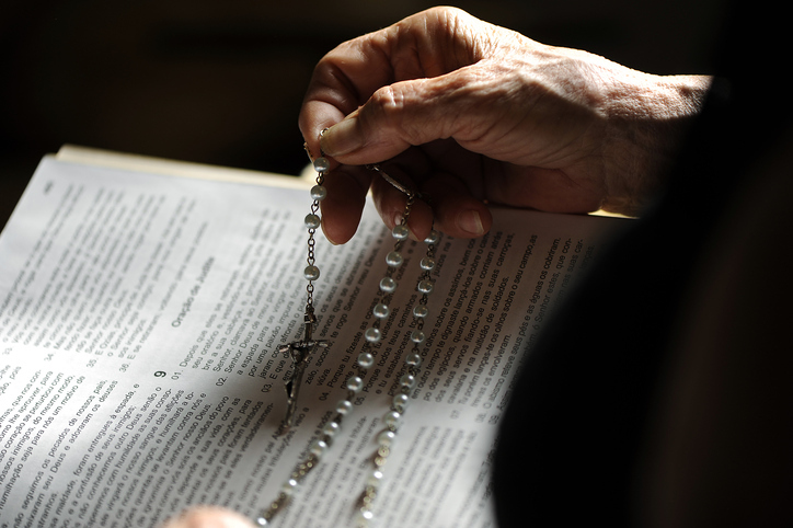 Hand hält Rosenkranz