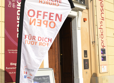 'KIrche offen für Dich!' Beachflag vorm Trauer-Raum der Gesprächsinsel.
