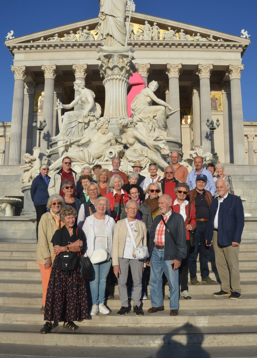 Eine Gruppe Senioren steht auf den Stufen vor dem Parlament