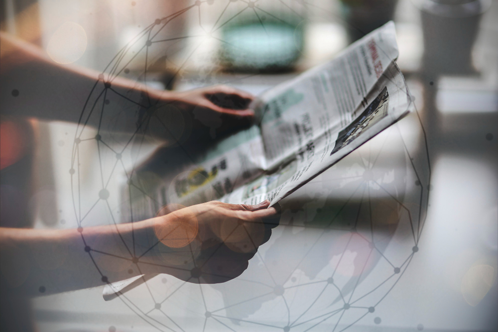 2 Hände mit einer Zeitung in Lesehaltung