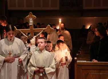 Der Einzug mit der entzündeten Osterkerze in die finstere Kirche. Monsignore Dr. Johannes Fürnkranz und Ministranten.