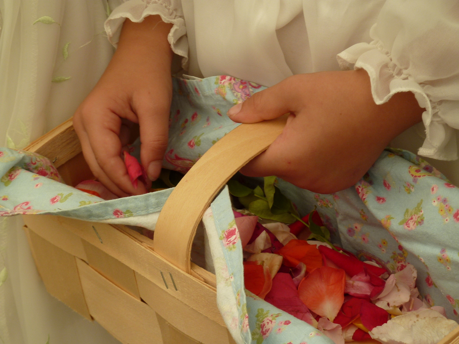 Kinderhände am Korb mit Blütenblättern