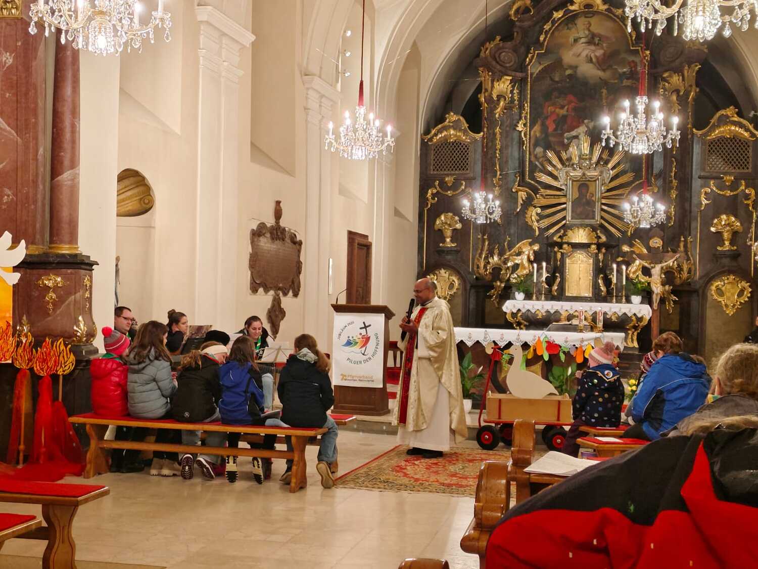Priester erklärt den Kindern das Martinsfest