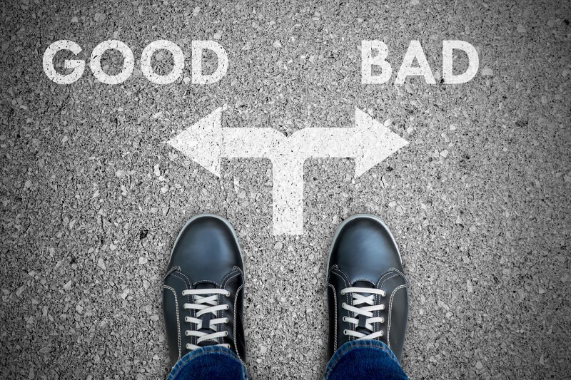 Black casual shoes standing at the crossroad making decision good or bad.