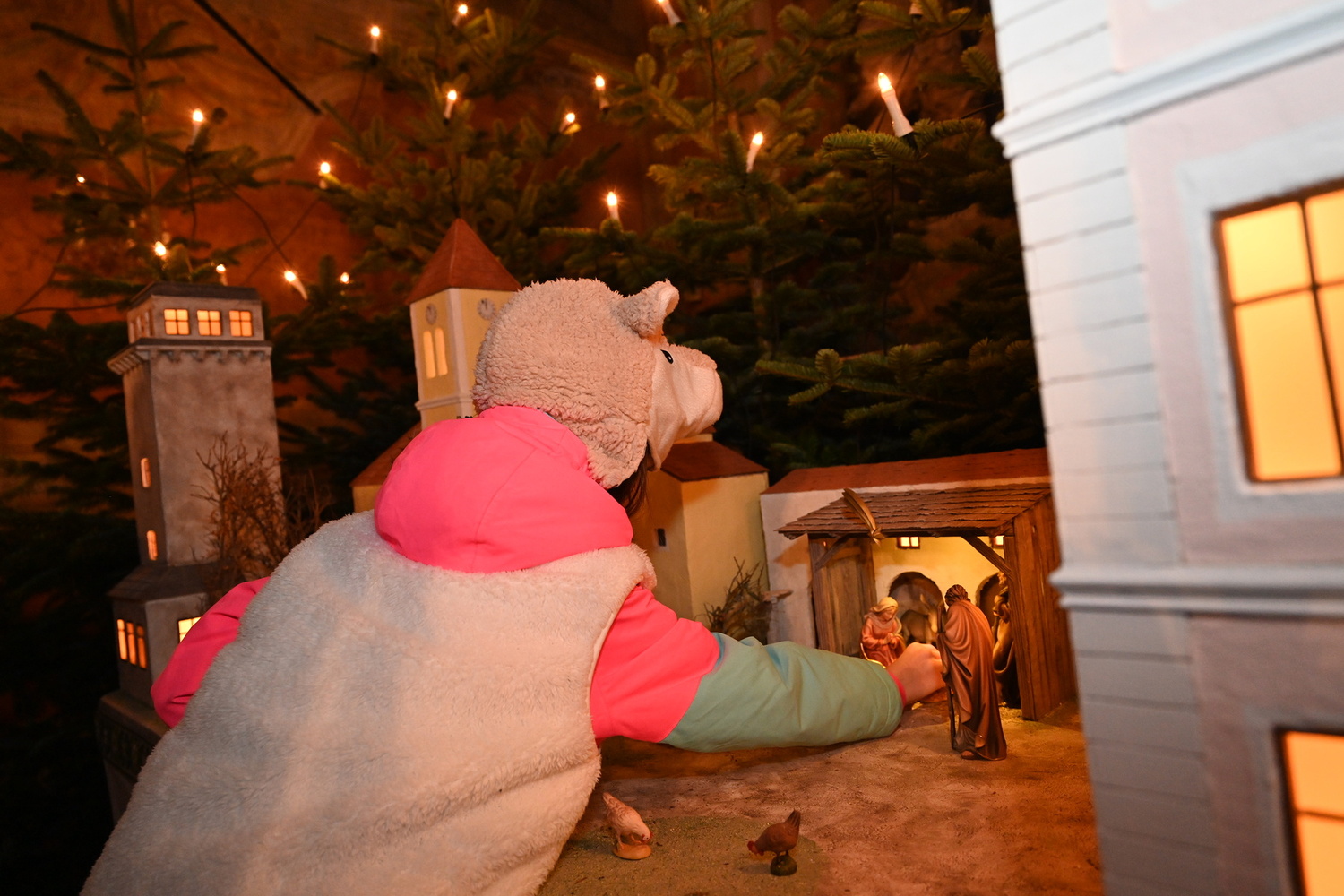 Mädchen legt das Jesukind in die Krippe