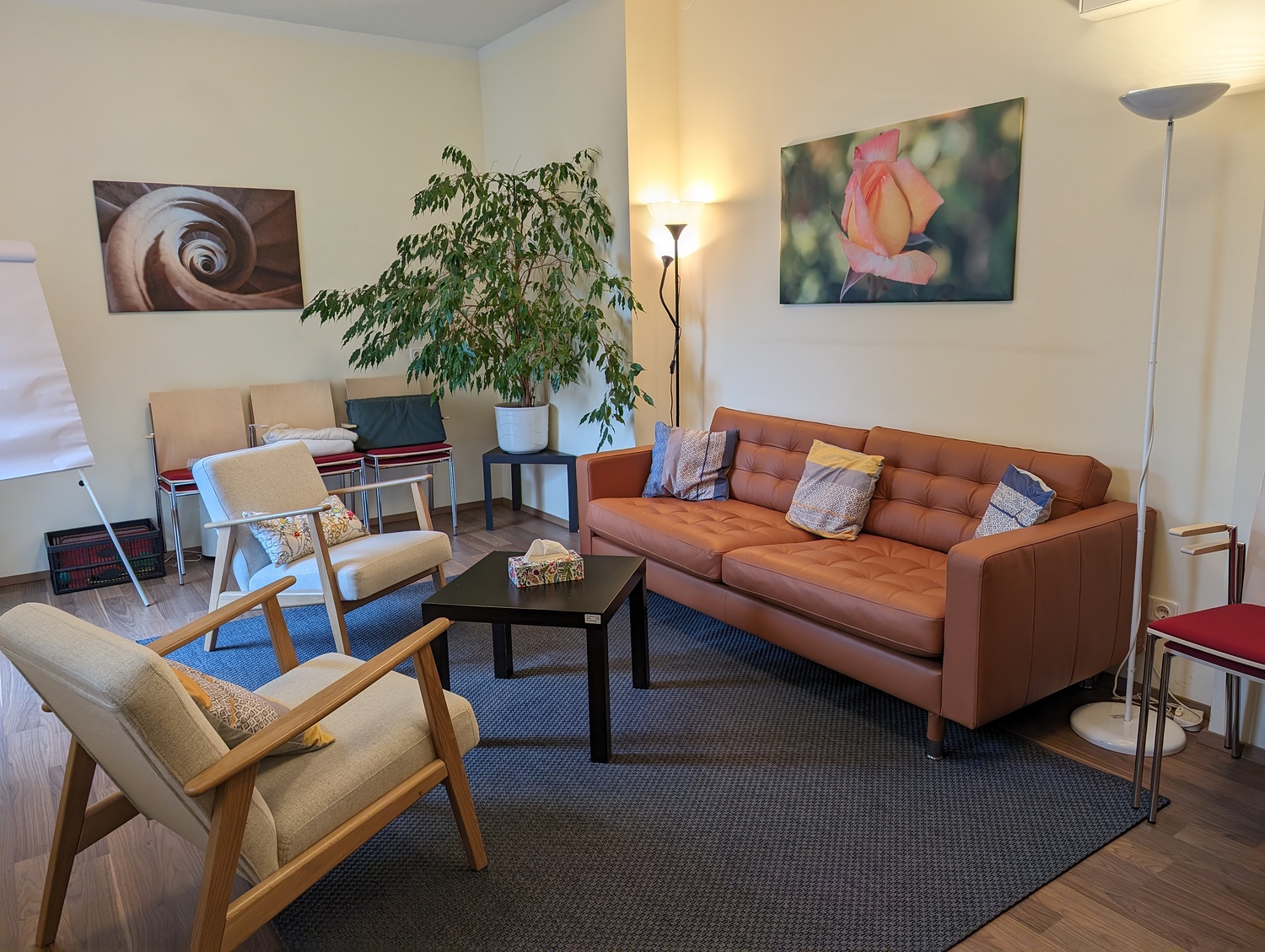 Gemütlicher Beratungsraum mit Ledersofa, zwei Sesseln und Couchtisch.
