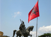 Albanienflagge und Statue/Flickr