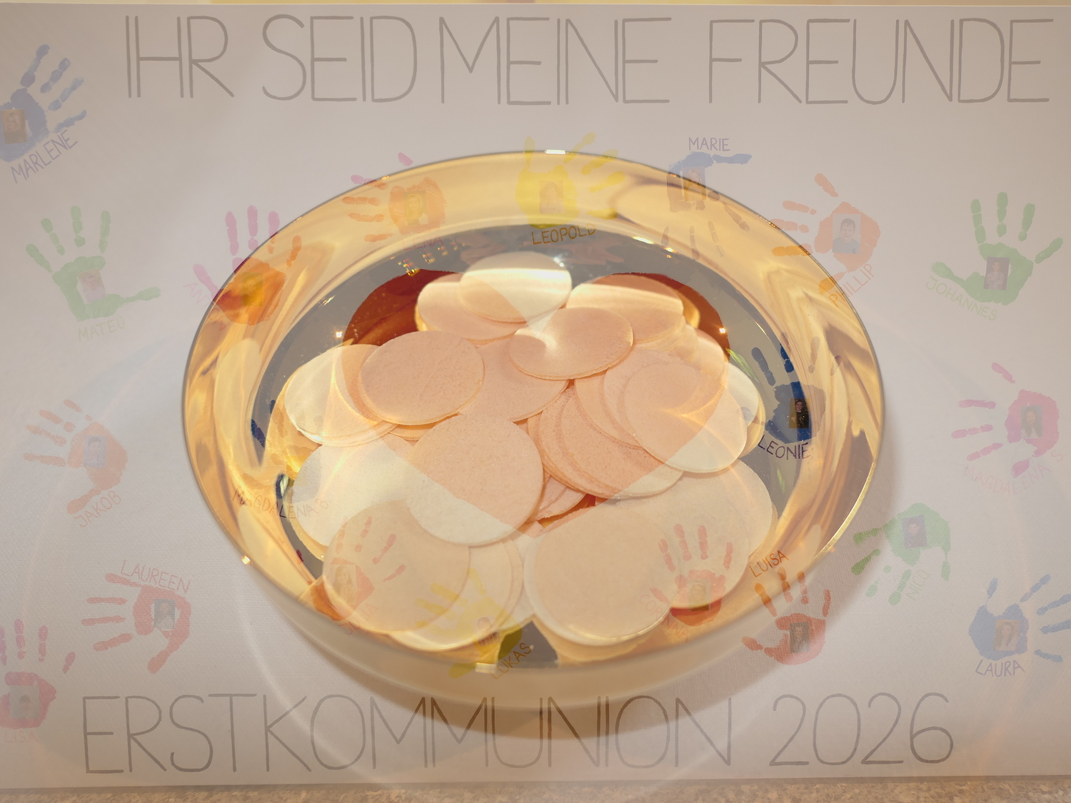 Hostienschale im Hintergrund Tafel der Erstkommunionkinder