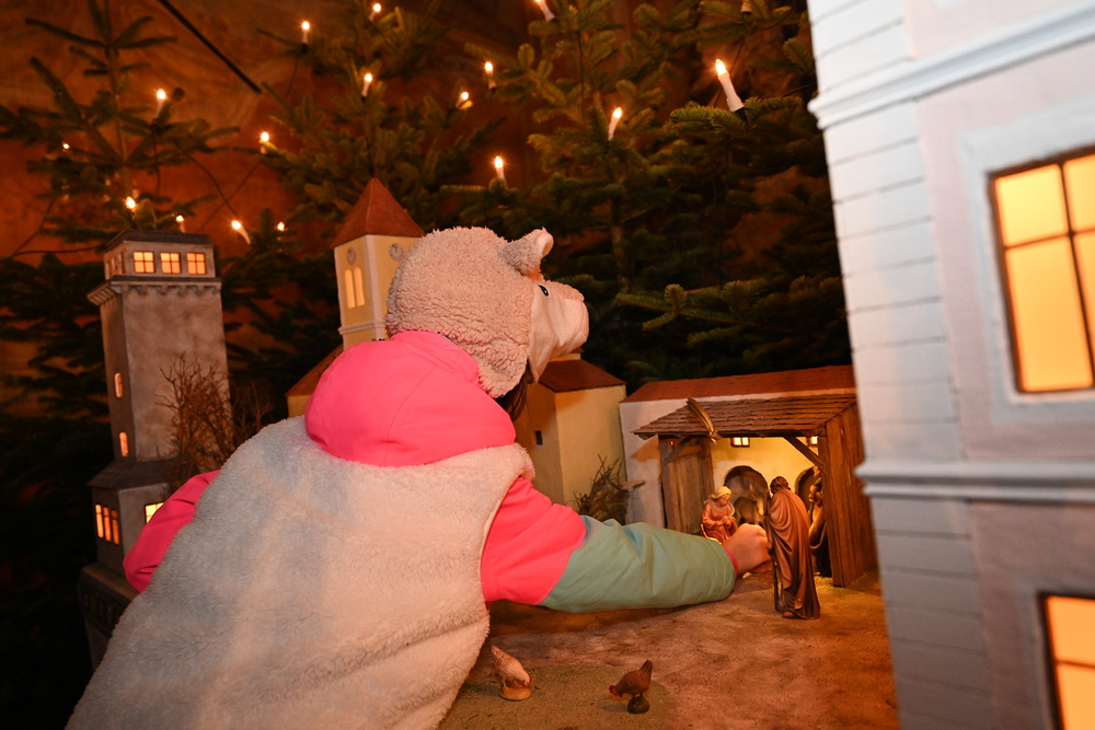 Mädchen legt das Jesukind in die Krippe