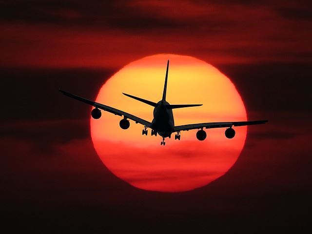 Flugzeug fliegt in den Sonnenuntergang