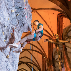 Johannes Hofherr kletterte während der BE BLESSED Segensfeier an einer Kletterwand im Stephansdom.