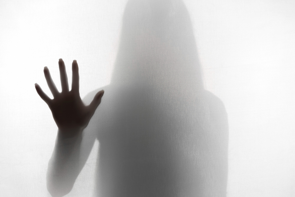 Frau verschwommen im Nebel hält eine Hand abwehrend vor sich