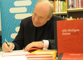 Kardinal Schönborn beim signieren des Buchs 