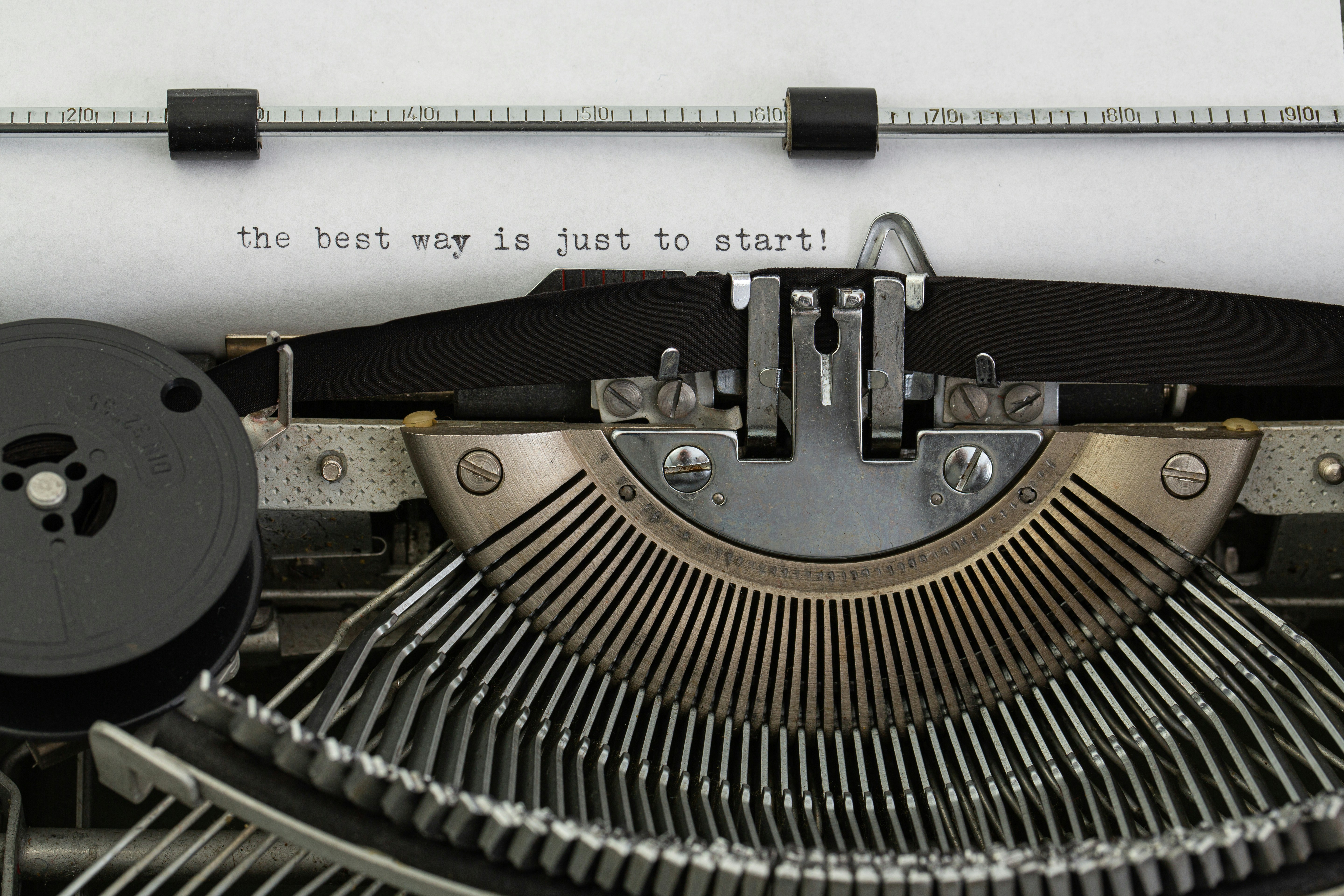 Nahaufnahme einer Schreibmaschine, auf deren eingespanntem Papier der englische Satz „the best way is just to start!“ getippt ist