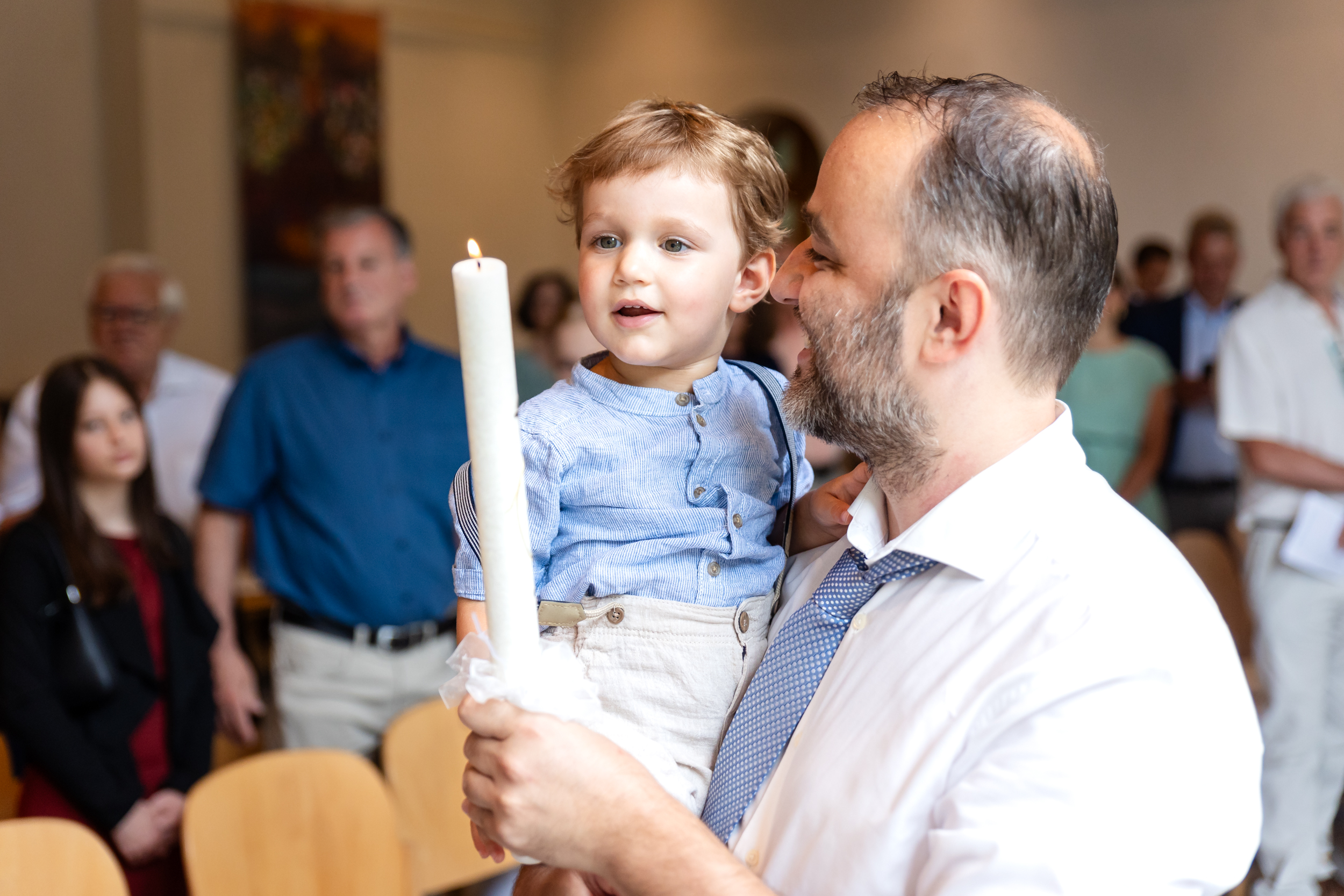 Kind und Vater mit Taufkerze