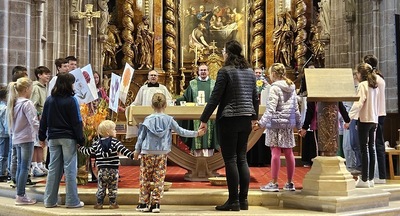 Kinder rund um Altar, Hände gereicht