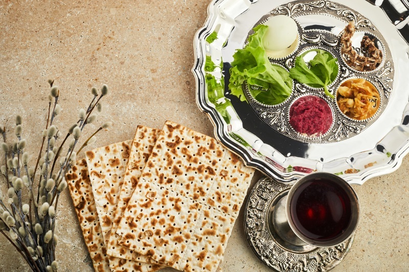 Passover Seder plate with traditional food ontravertine stone background.