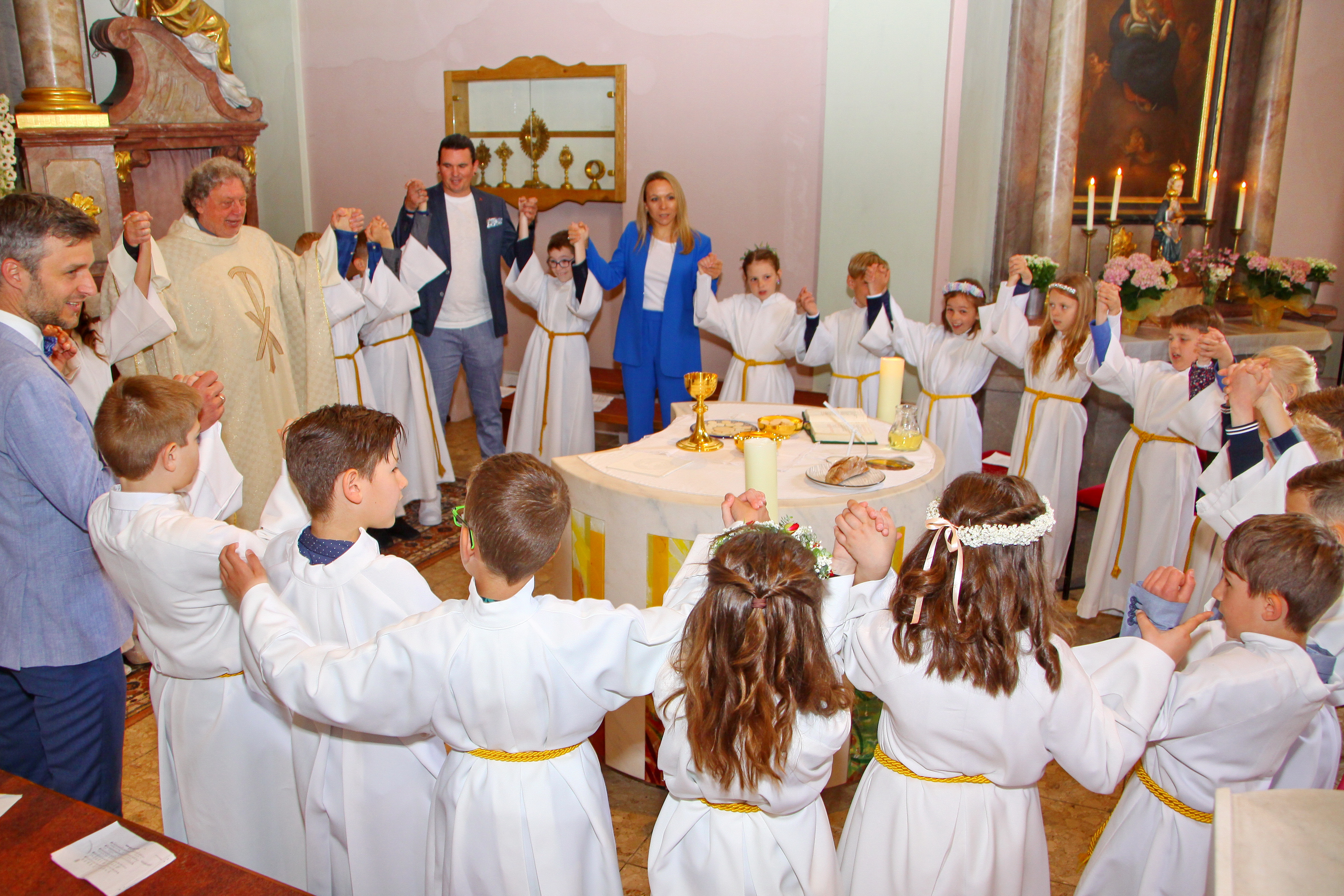 Erstkommunionkinder stehen um den Altar