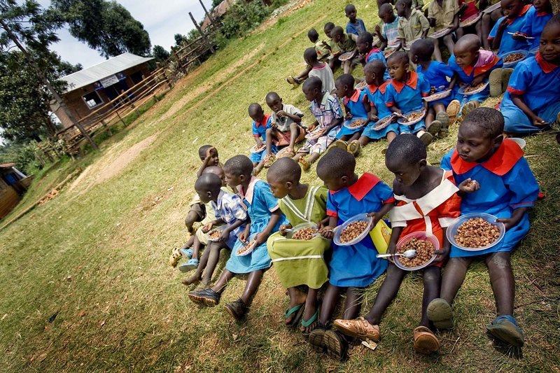 A group of school children eat a meal outside  their newly constructed kitchen at their school in Enchoro, Western Kenya on 19th February, 2009. Mary's Meals, a Scottish NGO, alongwith Tescoes supermarket sponsor each child at the school to have one 