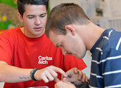 Caritas-Mitarbeiter betreut Menschen mit Behinderung / www.caritas.at