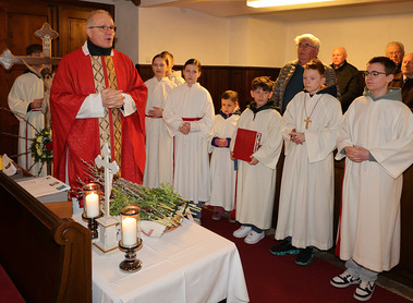 Pfarrer P. Michael segnet zu Beginn der heiligen Messe alle Palmzweige. 