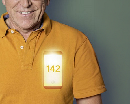 Lächelnder Mann, der ein Smartphone mit der Nummer 142 in der Nähe des Herzens hat